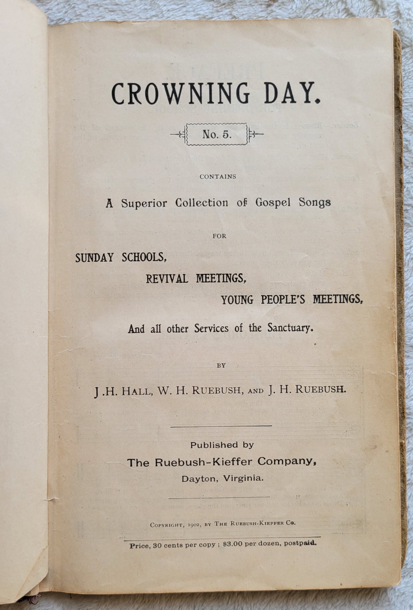 Antique book Crowning Day No. 5 is a Christian hymn book, copyrighted in 1902 by J. H. Hall, W. H. Ruebush, and J. H. Ruebush and published by the Ruebush-Kieffer Company, Dayton, Virginia. View of inside title page.