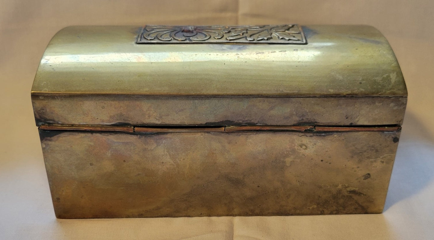 Antique brass box curio made in China, with a domed lid. The interior bottom has wood inserts on three side (one side is missing). The exterior has welded medallions with Chinese characters and designs. View of back.