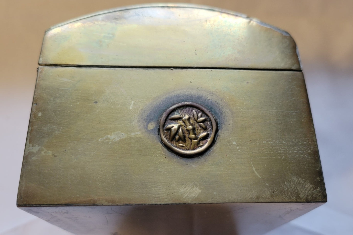 Antique brass box curio made in China, with a domed lid. The interior bottom has wood inserts on three side (one side is missing). The exterior has welded medallions with Chinese characters and designs. View of side