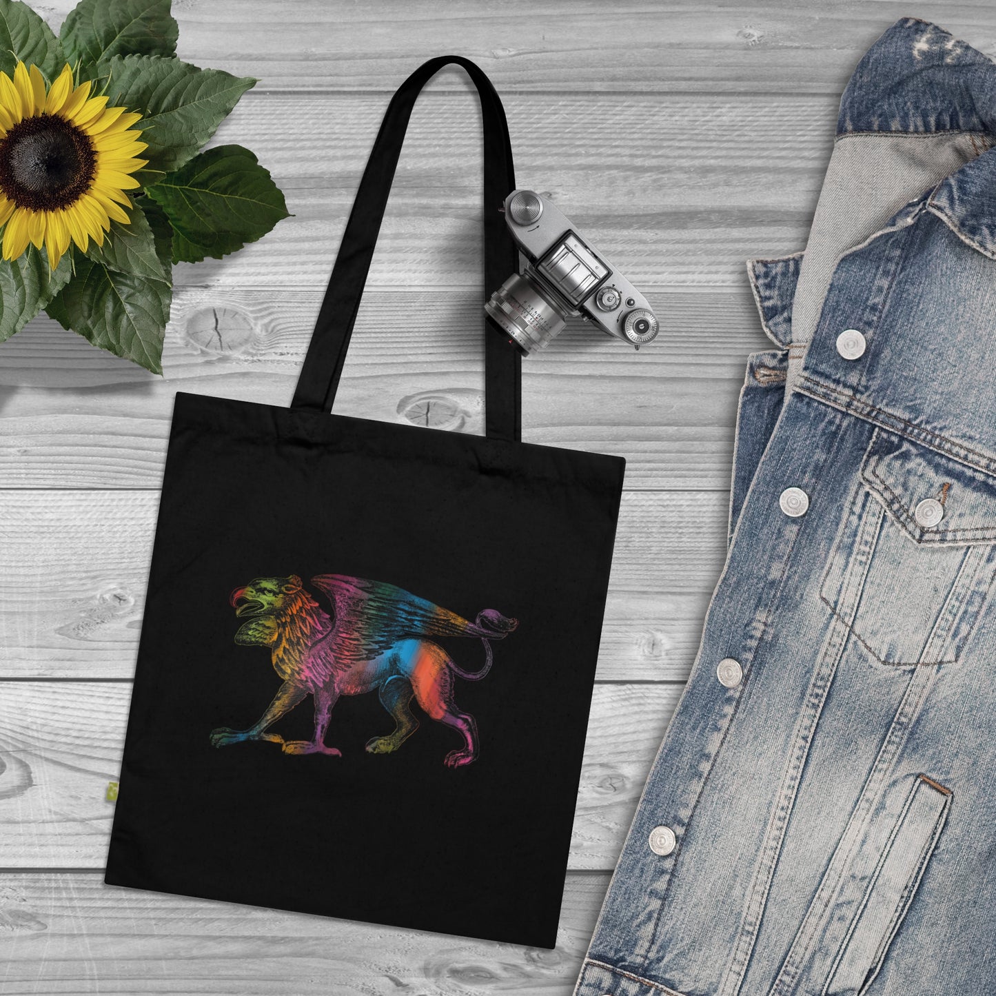 Black shopping tote with 17th century engraving of a griffin, colored in with multiple colors.