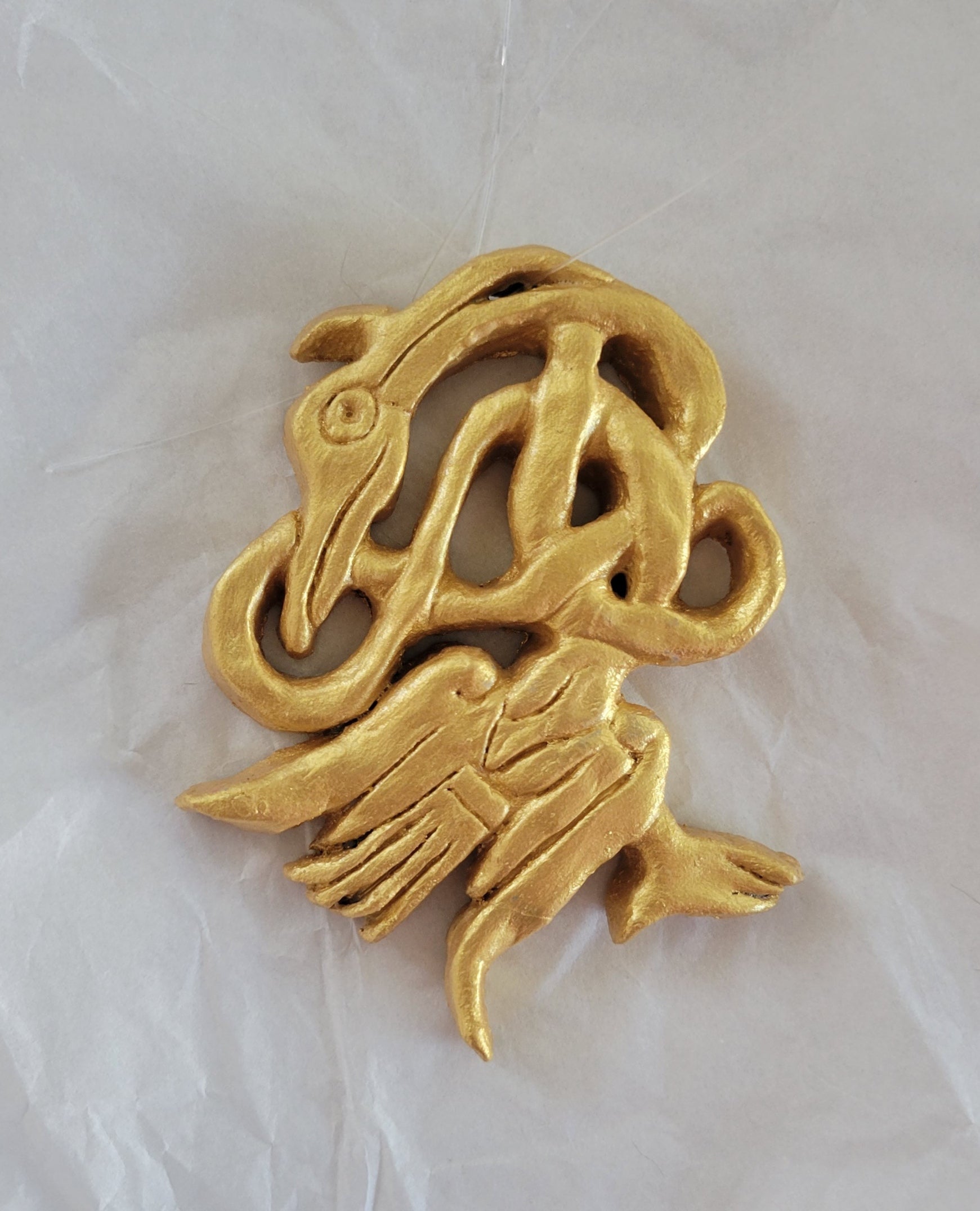 Golden Celtic bird ornament with Celtic knot work.  Hand made out of clay and hand painted.  Size: Approximately 3" x 4" 