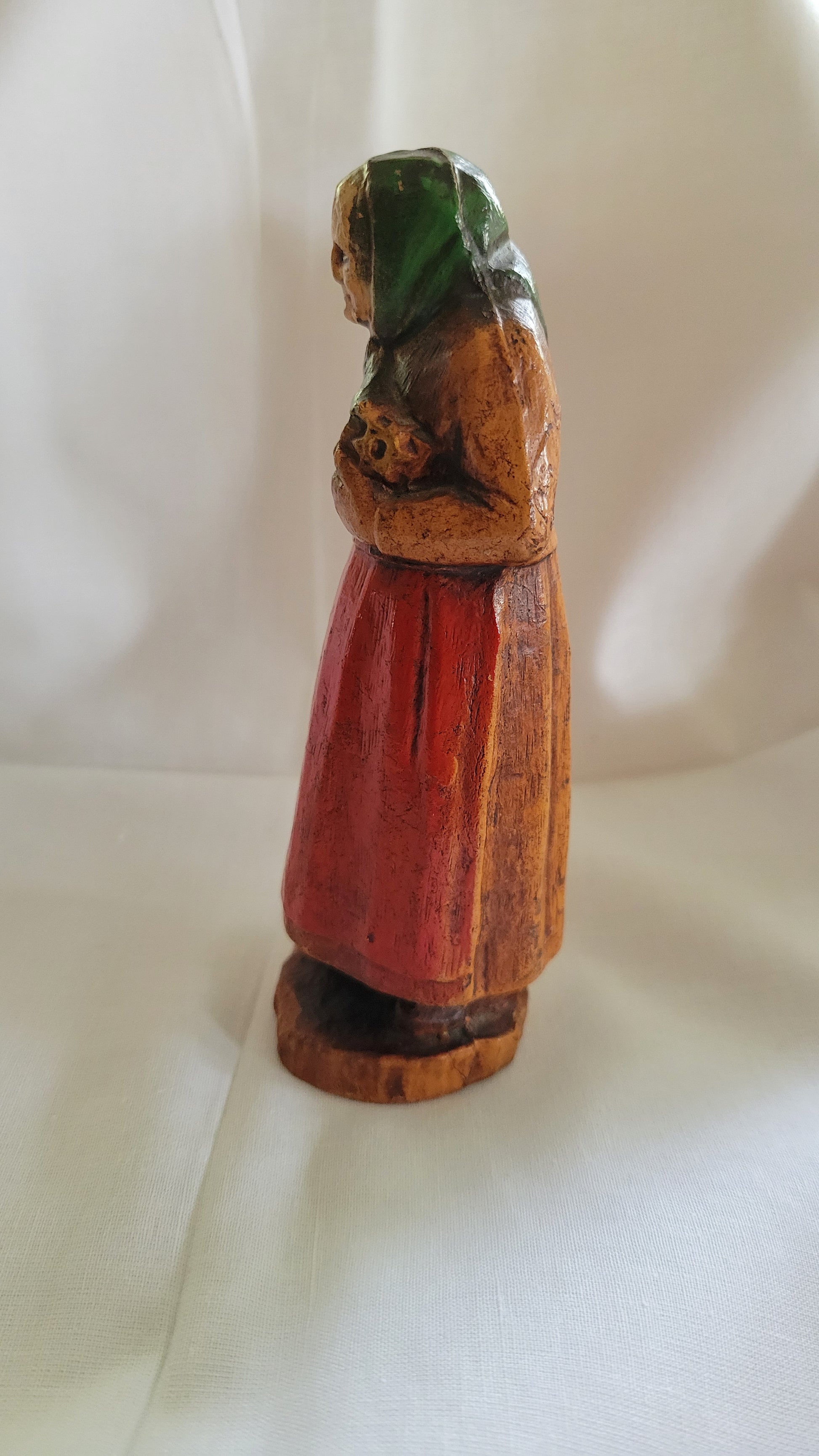 Small Jewish, Yiddish grandmother or Bubbe figure, antique, holding Jewish Bible, possibly SyrocoWood. Left view.