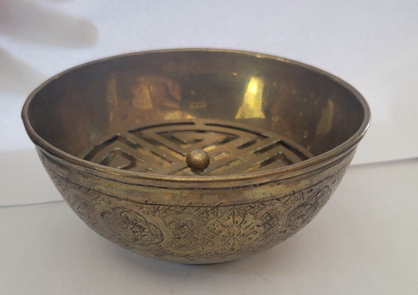Vintage brass incense bowl with insert and engravings, front view.