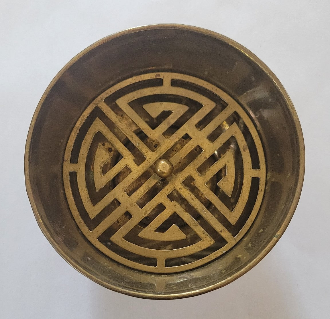 Vintage brass incense bowl with insert and engravings, top view.