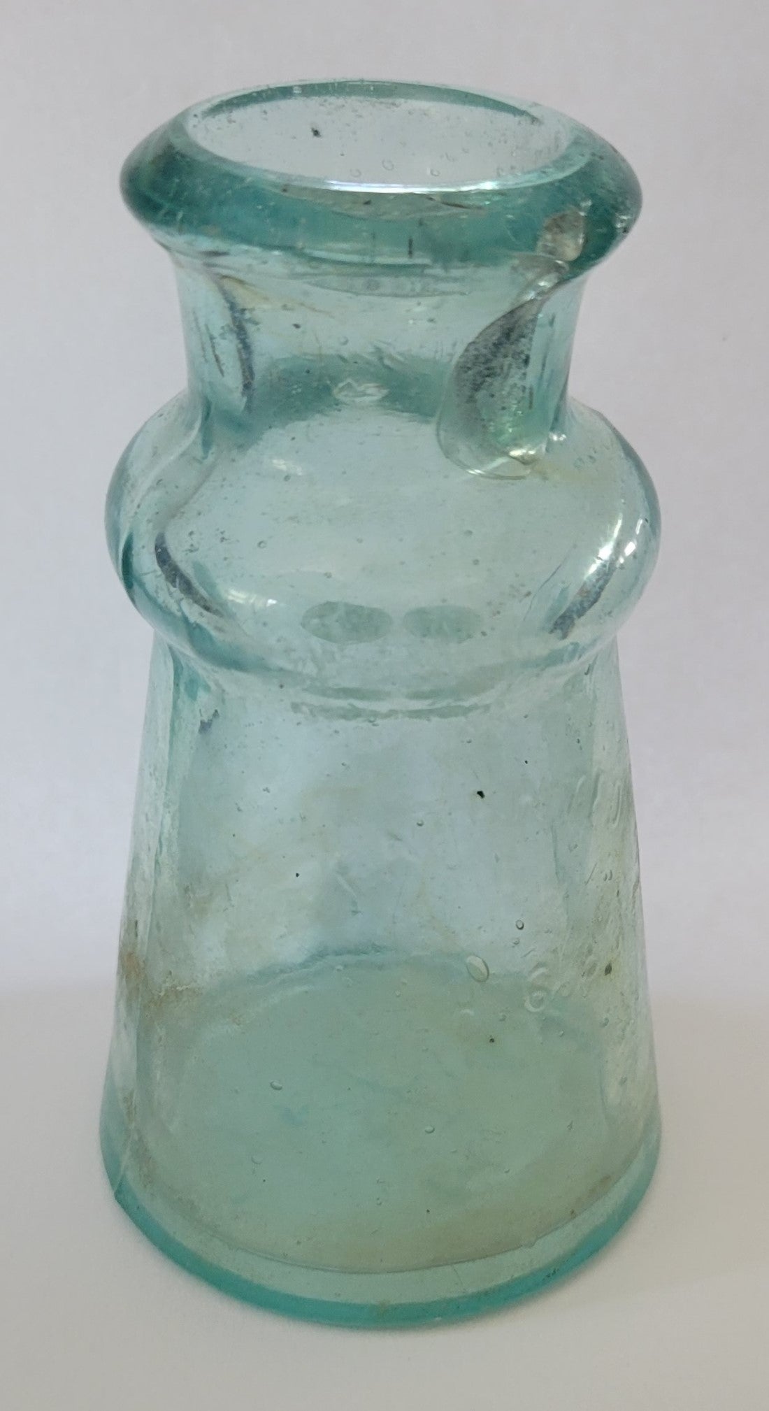 This thick aqua ink bottle was made by Bixby in 1883.  The bottom has the Bixby name and on the side is "Patented Mch. 6. 83" Front view.
