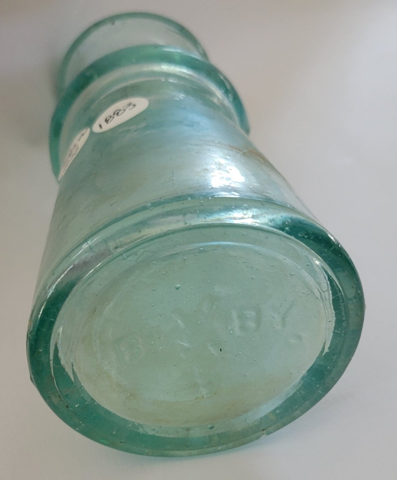 This thick aqua ink bottle was made by Bixby in 1883.  The bottom has the Bixby name and on the side is "Patented Mch. 6. 83" Bottom view.