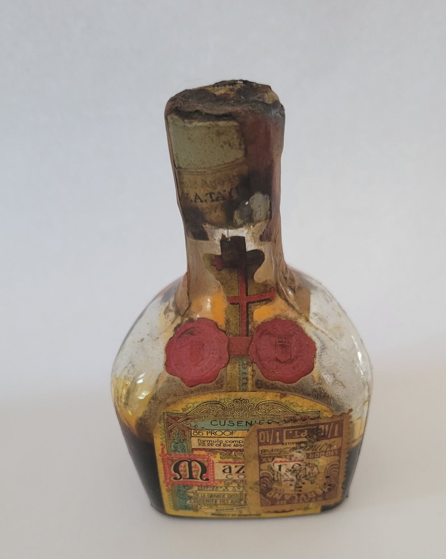 Vintage liquor bottle, little Mazarine liquor bottle from Argentina with State of Maryland Liquor Excise Tax sticker on the front. Front view.