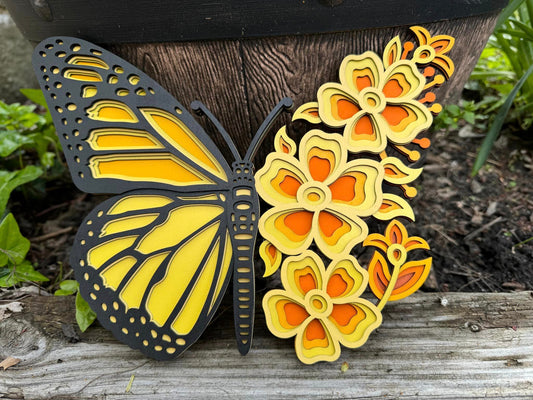 3D layered wood wall art, half butterfly half flowers, different shades of oranges and yellows with black accent.