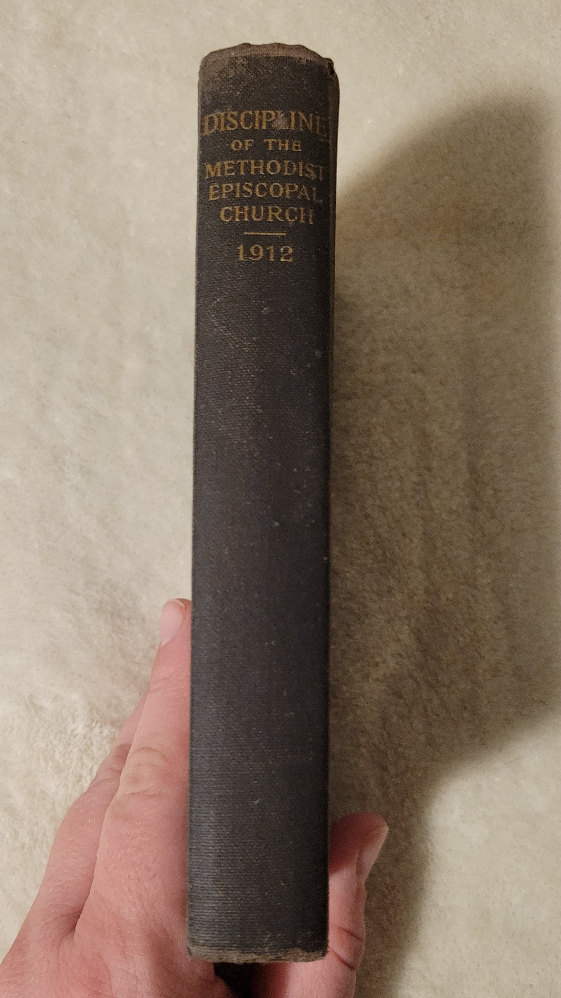 Antique book "Doctrines and Discipline of the Methodist Episcopal Church" published by the Methodist Book Concern, 1912. View of spine.