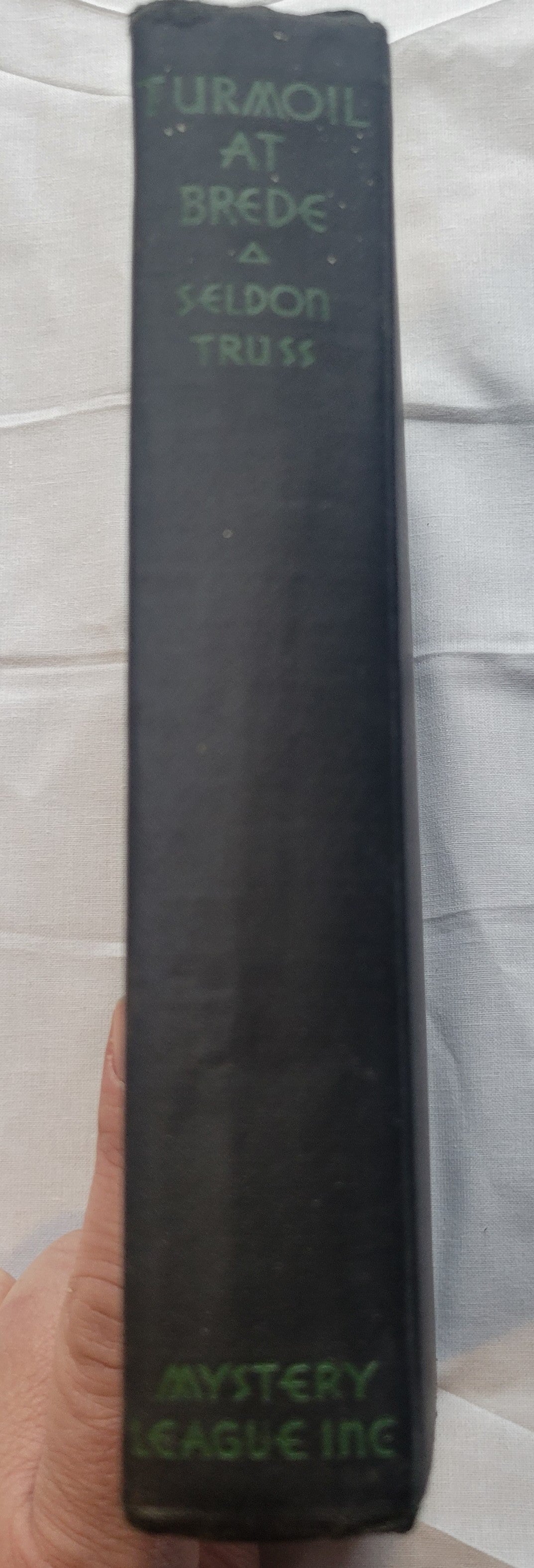 Antique book for sale “Turmoil at Brede, First Edition” by Seldon Truss, published by The Mystery League in 1931. Spine.