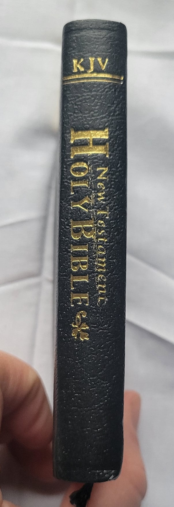 Used book for sale, Pocket size, red letter, King James Version New Testament. View of spine.