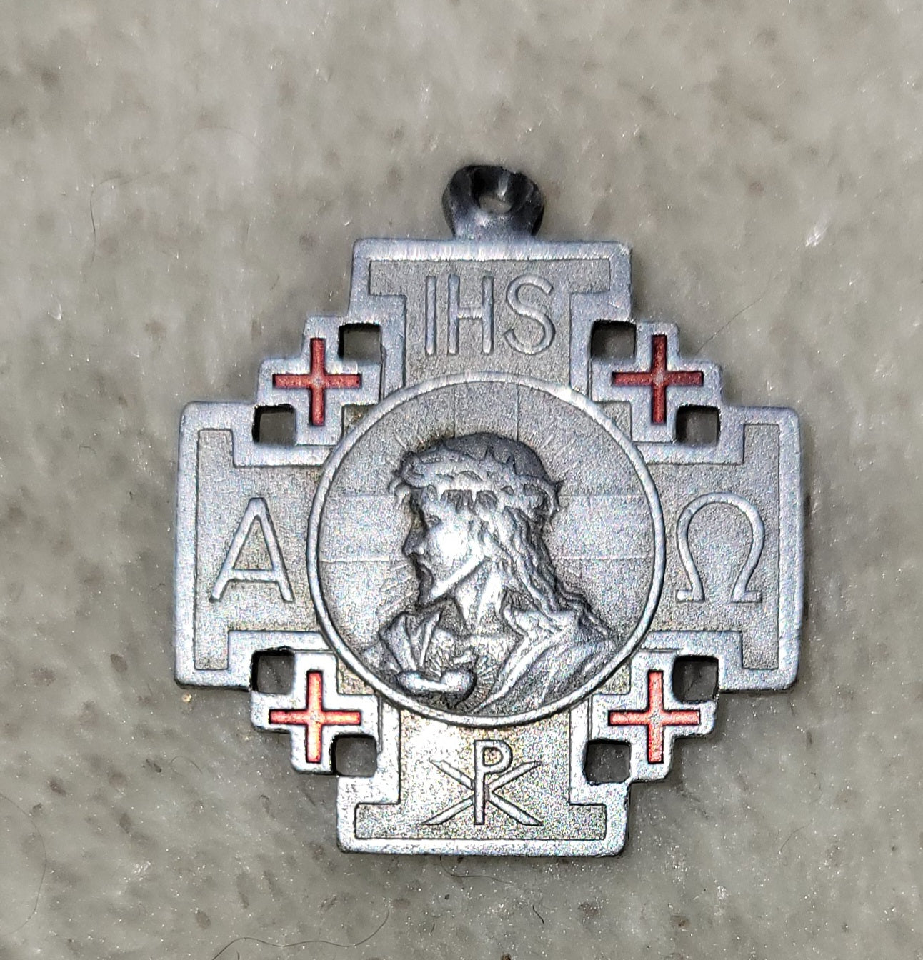 Jerusalem Cross of the Crusades pendent - a large cross surrounded by four smaller Greek crosses.  On one side of this pendent is and image of Jesus with the Chi Rho symbol (the P over the X) at the bottom.  The Greek letters to the side of the image of Jesus are alpha and omega, symbolizing the beginning and the end. On the other side is an image of Mary, the word "Crusade", the fleur de lis, and a star,  View of back.