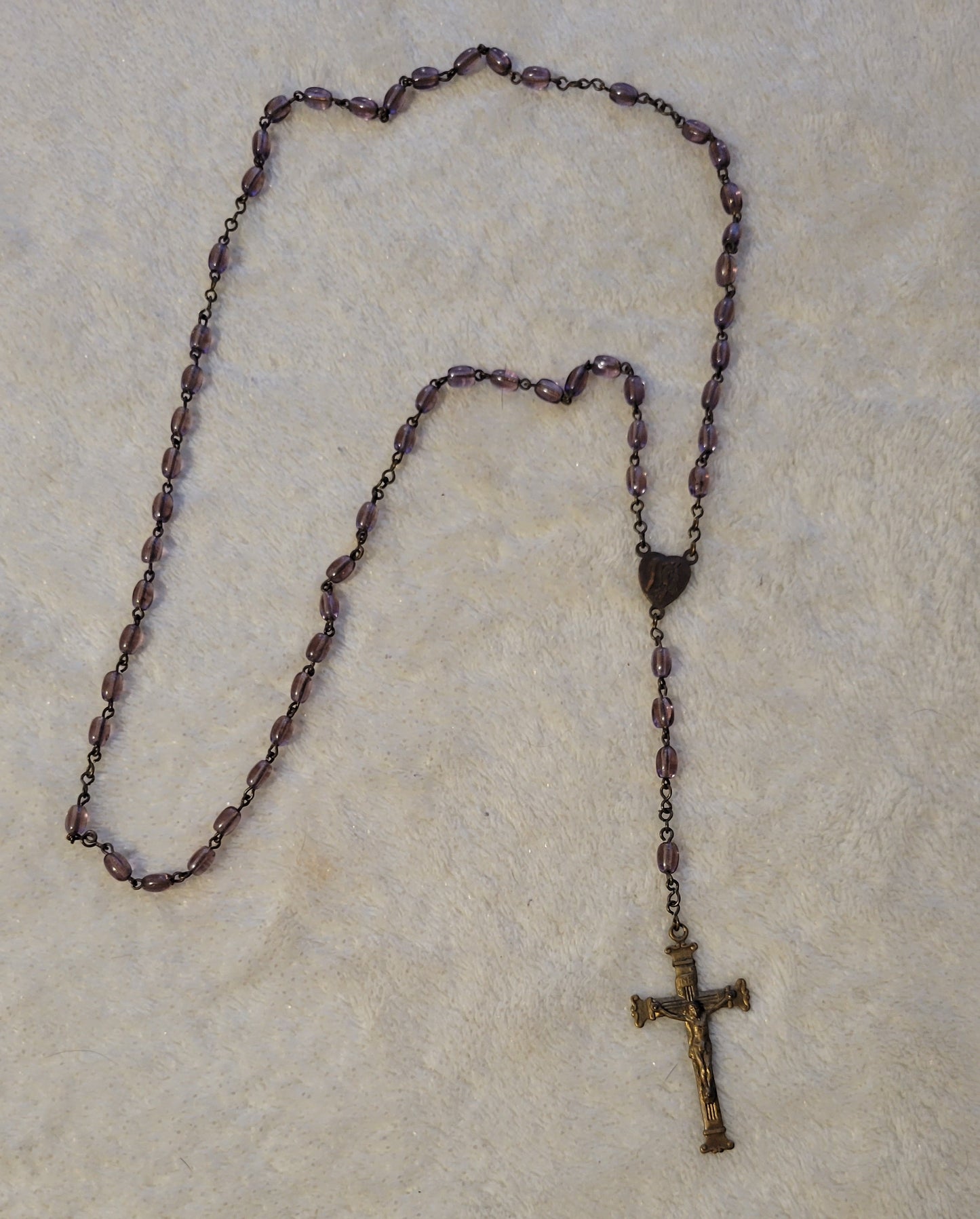 Christian Catholic rosary with crucifix and purple beads. Overall view.