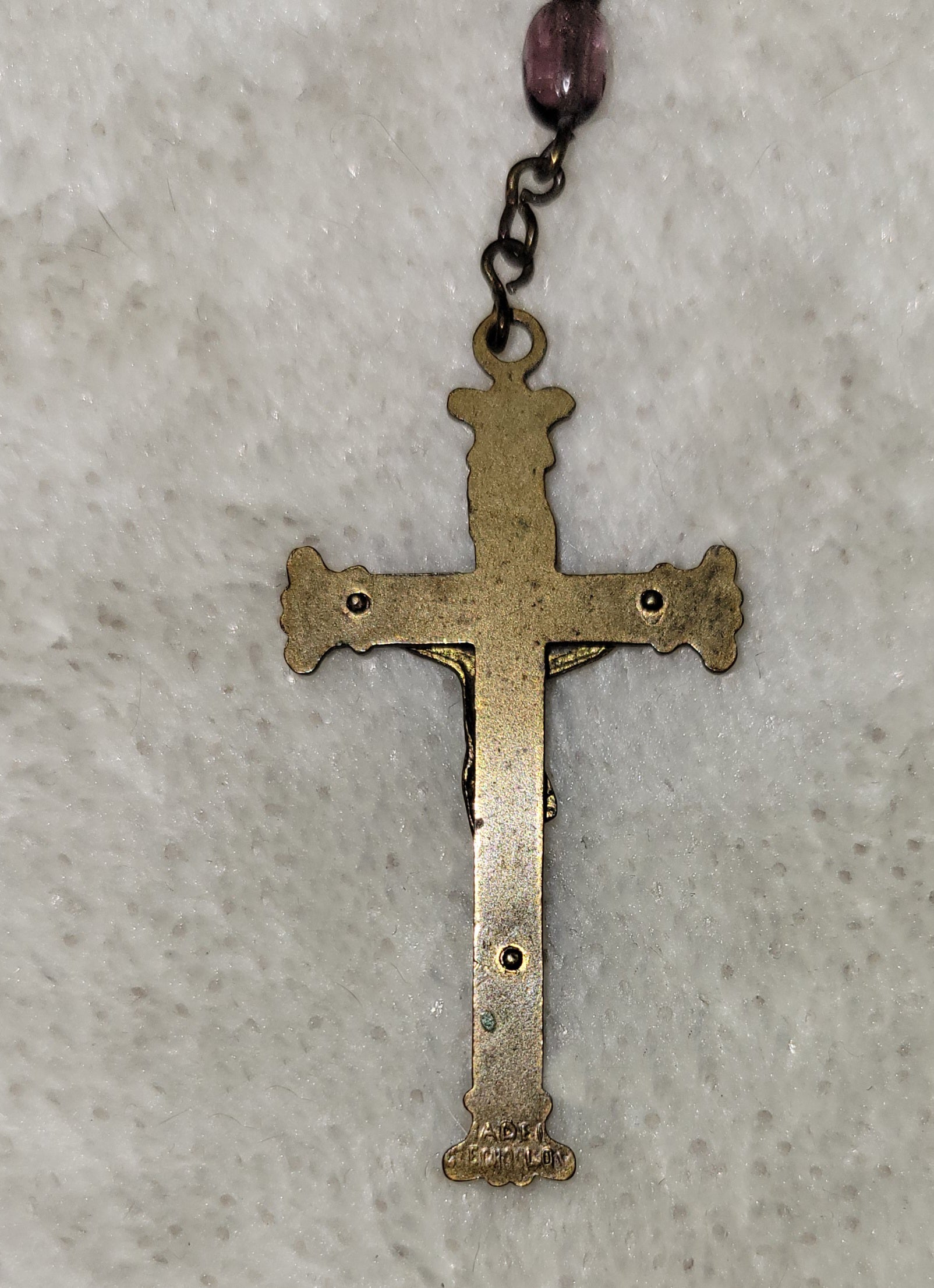Christian Catholic rosary with crucifix and purple beads. Back of crucifix.