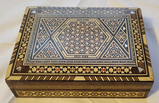 Vintage small, wooden mosaic box for sale, pattern made with stained wood, mother of pearl, and (presumably) ivory pieces. Top view.