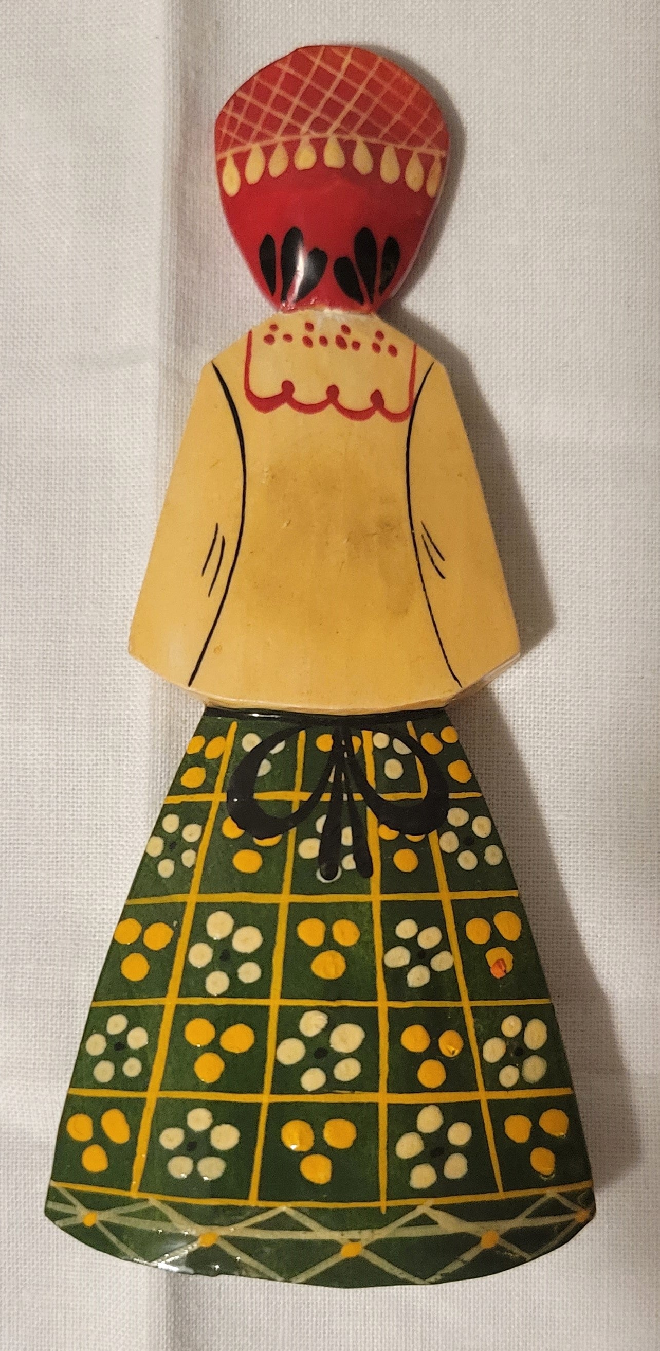 Small wooden doll made in Russia, with traditional dress. Back.