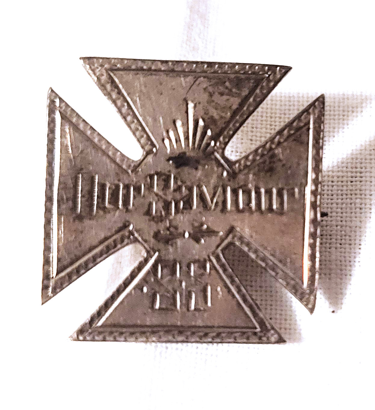 An antique Sunday School cross pin, with "Our Savior" engraved on the front of it. On the back, the name "Louis Fogelson" is engraved. Front view.