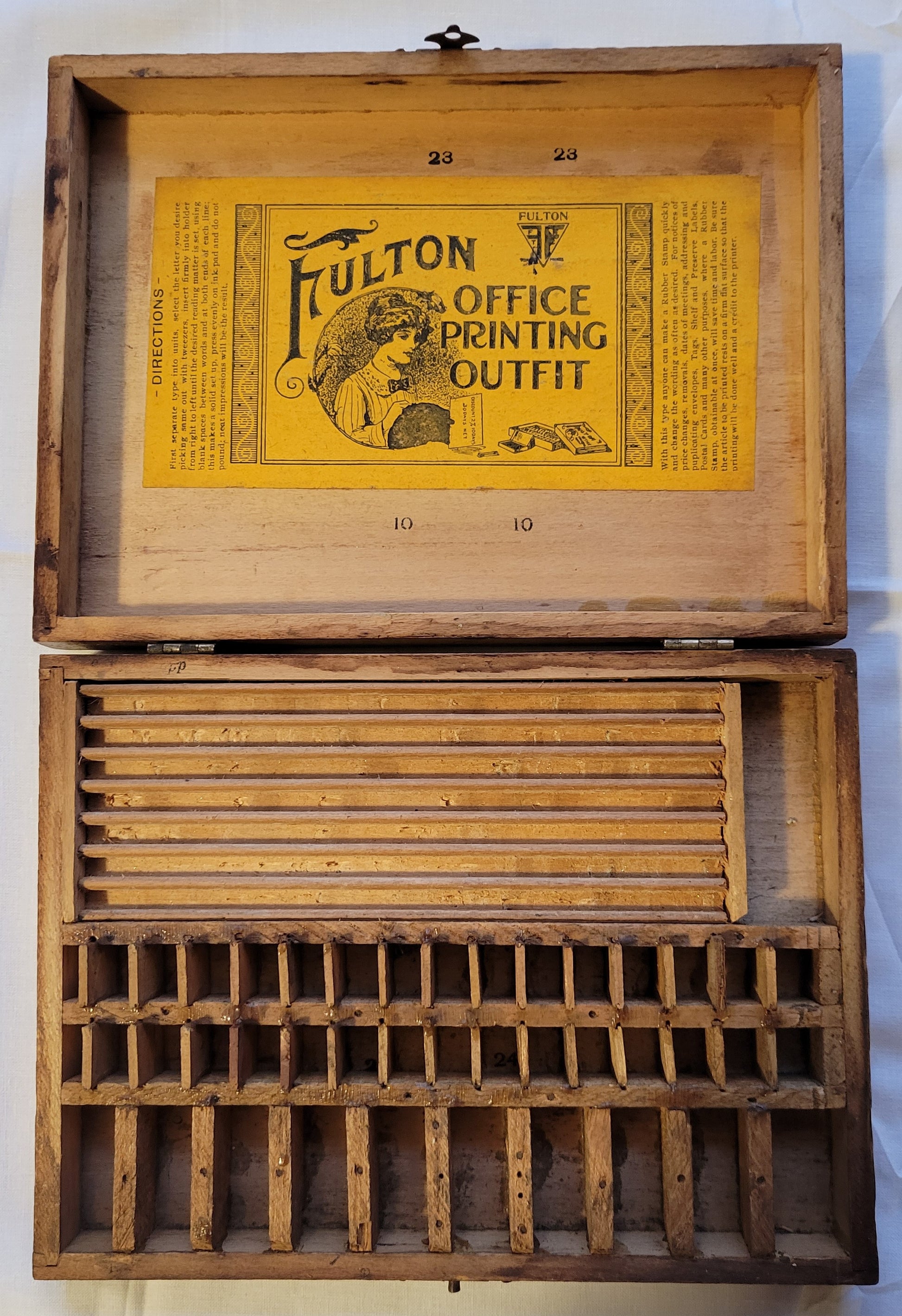 Antique wooden box that held the Fulton Office Printing Outfit custom rubber stamp kit.  View of inside with compartments and company sticker.