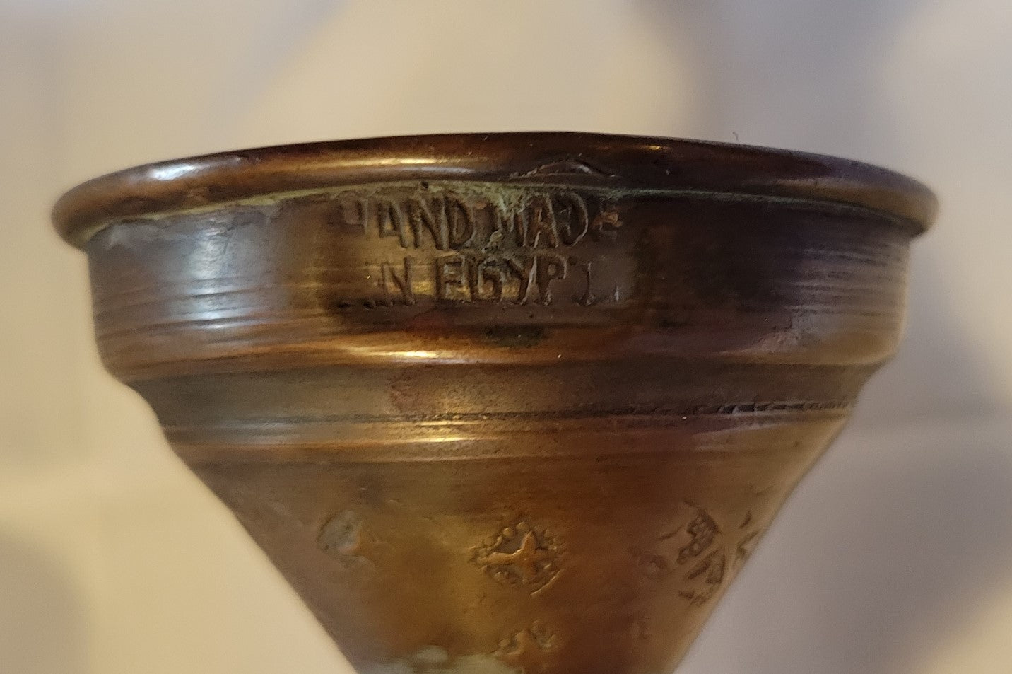 Antique, Egyptian copper kettle with a glazed turquoise scarab beetle on both sides.  The scarab beetle was a symbol of death and rebirth in ancient Egypt. View of base with the words "Handmade in Egypt"