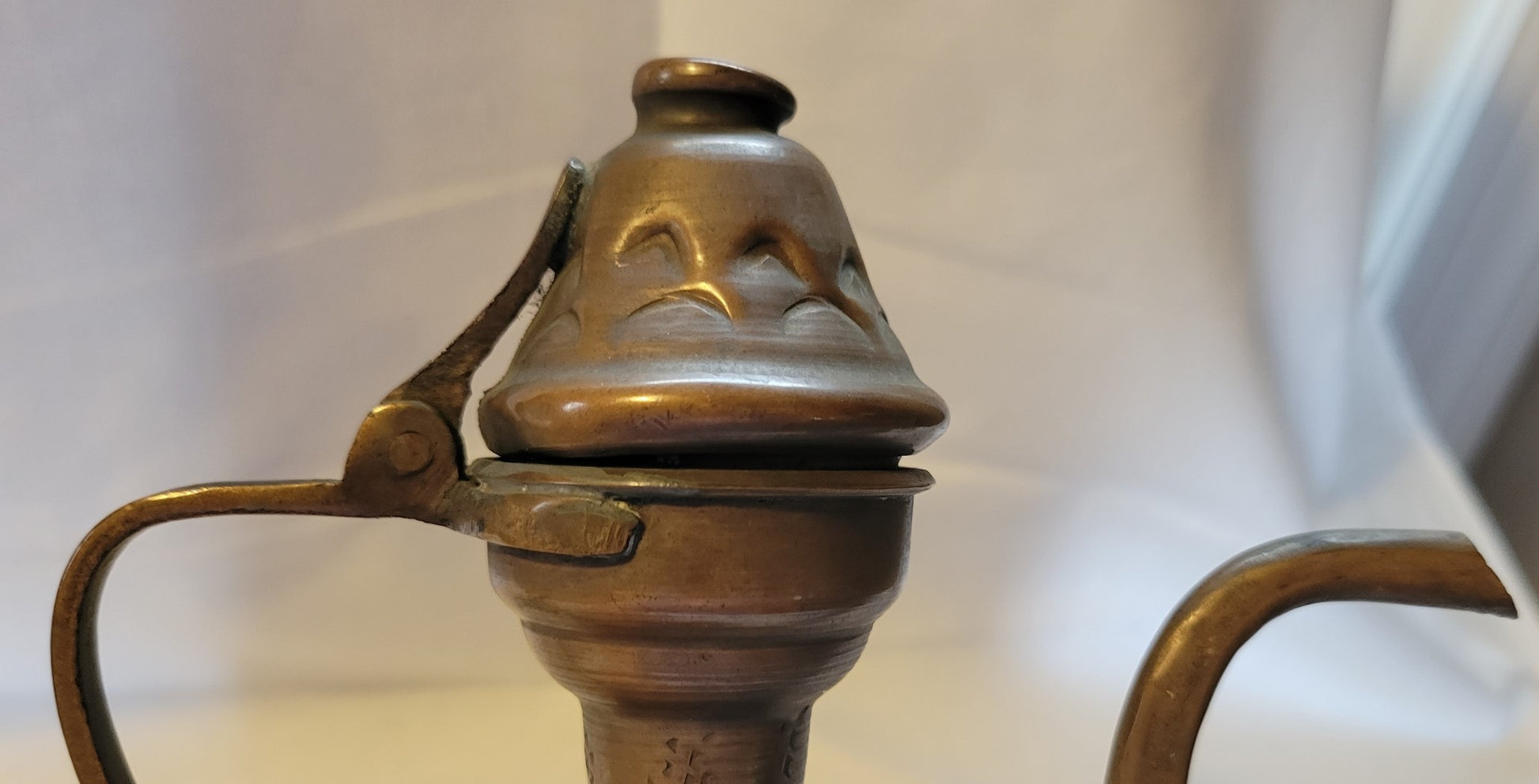 Antique, Egyptian copper kettle with a glazed turquoise scarab beetle on both sides.  The scarab beetle was a symbol of death and rebirth in ancient Egypt. Close-up view of top with hinged lid.