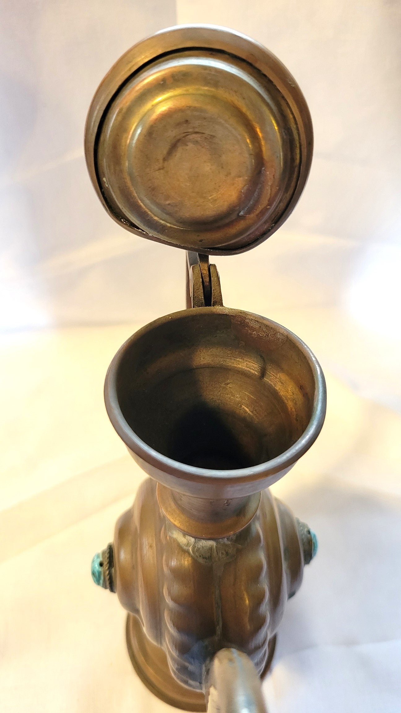 Antique, Egyptian copper kettle with a glazed turquoise scarab beetle on both sides.  The scarab beetle was a symbol of death and rebirth in ancient Egypt. View of top with open lid.