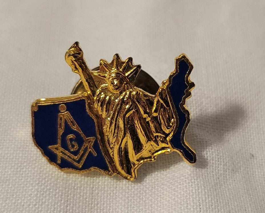 Collectible Masonic pin with Freemason square and compass on a blue United States and gold Statue of Liberty.